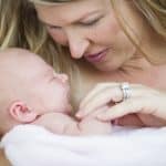 Mama delikatnie trzyma noworodka na rękach