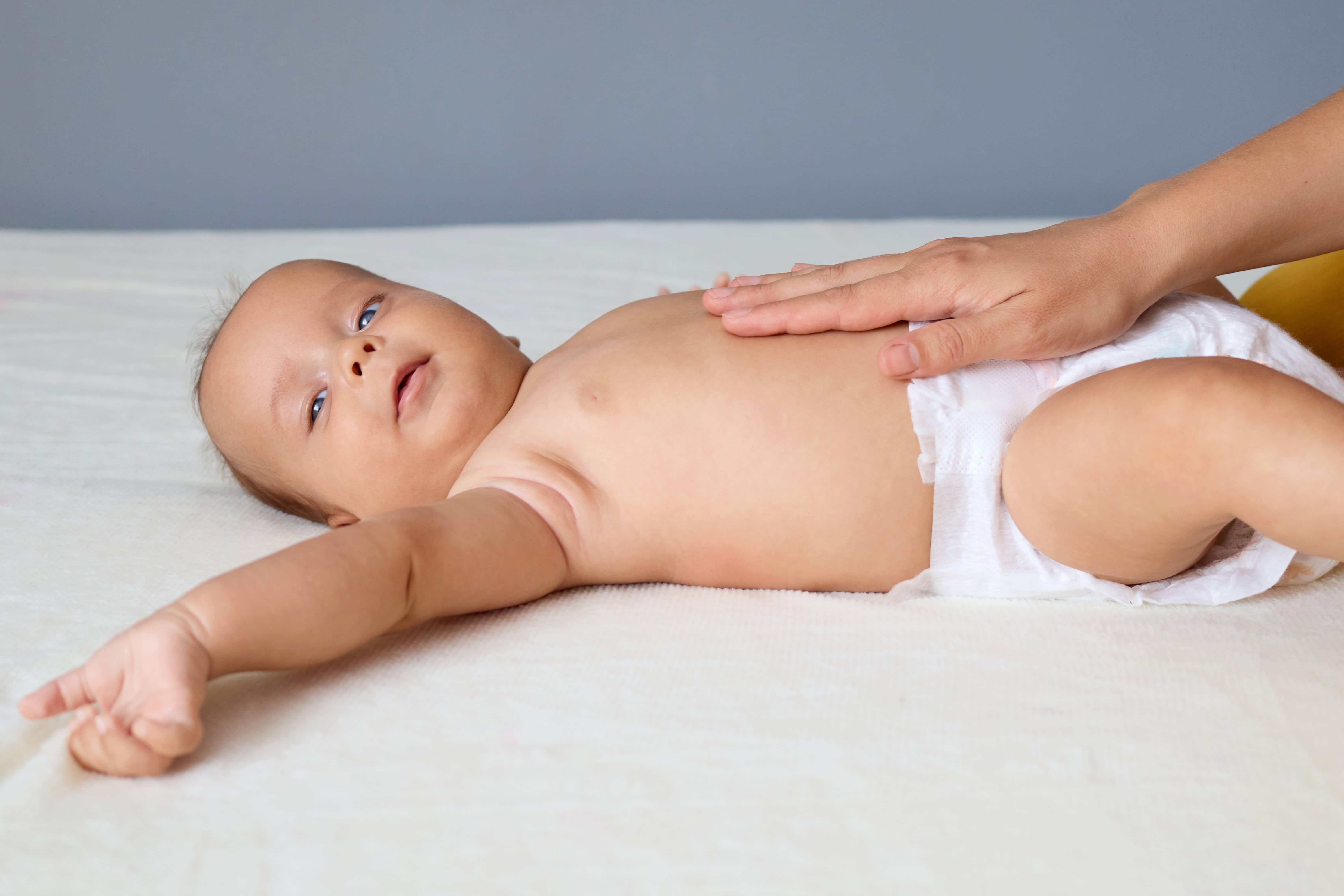 Delikatny masaż brzuszka niemowlęcia pomagający przy ulewaniu